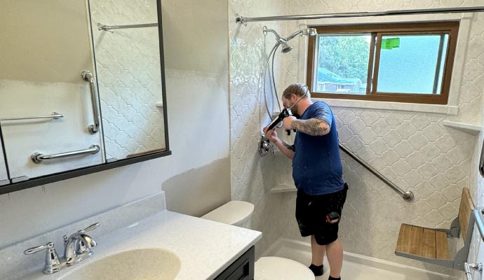 Professional bathroom remodeling and shower installation services Expert installing shower during bathroom remodel